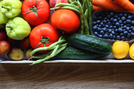 Wooden crate full of healthy seasonal fruit and vegetable. Top view, wooden background.の写真素材