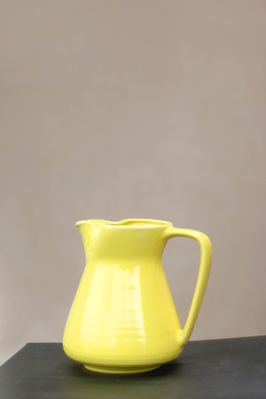 Retro yellow vase on the table, minimal concrete background. Selective focus.の写真素材