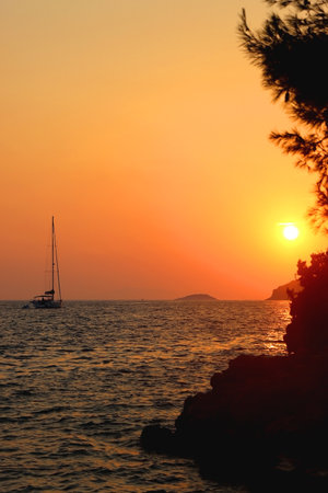 Sailing boat and beautiful sunset in Vela Luka, on island Korcula, Croatia.の写真素材