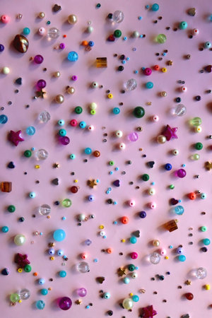 Various colorful beads on bright pink background. Top view.の写真素材