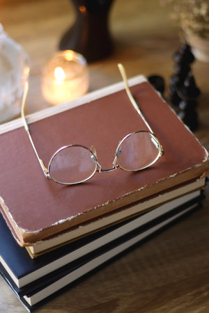 Vintage books, reading glasses, gold pen, hand model, gold jewelry, scented candles, flowers, chess...