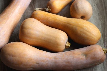 Pile of homegrown pumpkins on wooden table. Selective focus.の写真素材