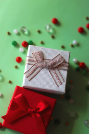 Two small presents and colorful beads on green background. Selective focus.の写真素材