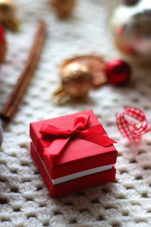 Various colorful Christmas ornaments, small presents and seasonal spices on white knitted blanket. Selective focus.の写真素材