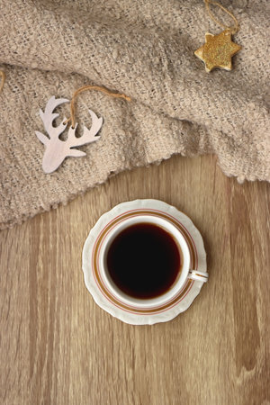 Bowl of cookies, cup of tea, dry oranges, pine cones, book, reading glasses and various neutral Christmas decorations on soft beige blanket. Cozy Christmas hygge. Top view.の写真素材