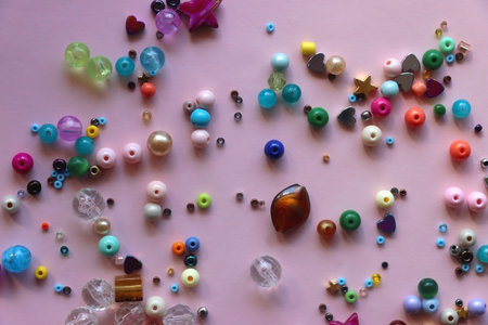 Various colorful beads on bright pink background. Top view.の写真素材