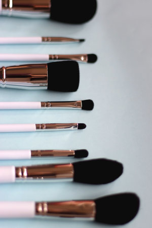 Various make up brushes on bright blue background. Selective focus.の写真素材