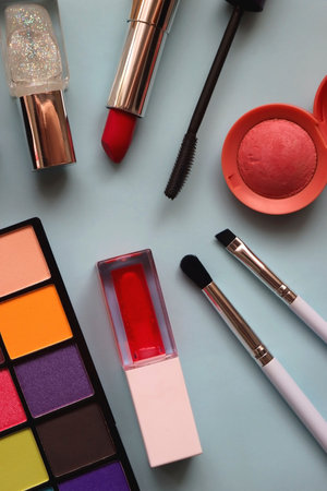 Various colorful make up products on bright blue background. Flat lay.の写真素材