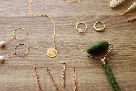 Pearl headband and barrette, golden eyeglasses, gold necklace, earrings and rings, jade face roller...