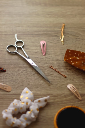 Wooden hairbrush, scissors and various headbands, hair clips and scrunchies on wooden background. Selective focus.の写真素材