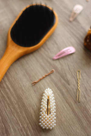 Wooden hairbrush, scissors and various headbands, hair clips and scrunchies on wooden background. Selective focus.の写真素材