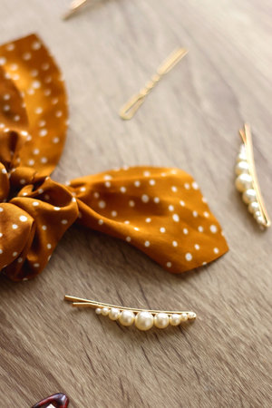 Wooden hairbrush, scissors and various headbands, hair clips and scrunchies on wooden background....