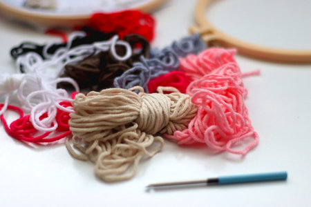 Colorful wool, embroidery hoop and punch needle on white background. Punch needle kit. Selective...