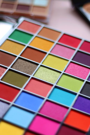 Various colorful eyeshadow palettes on bright pink background. Selective focus.の写真素材