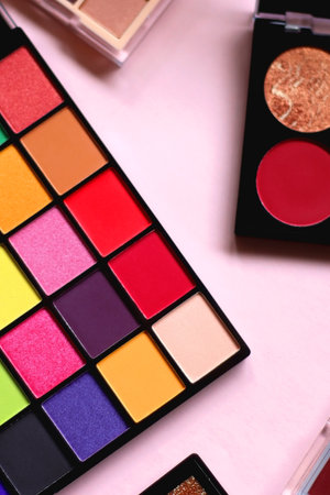 Various colorful eyeshadow palettes on bright pink background. Selective focus.の写真素材