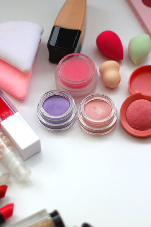 Various colorful beauty products on white background. Selective focus.