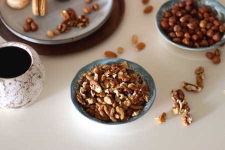 Cup of tea or coffee, cookies, macaroons, chocolate, various nuts and cocoa powder on white...