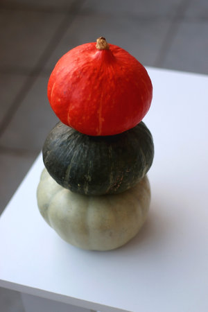 Pile of three different pumpkins on the table. Cute autumnal decoration. Selective focus.の写真素材