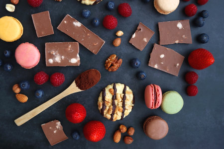Macarons, chocolate, cookies, berries and various nuts on dark blue background. Top view.の写真素材