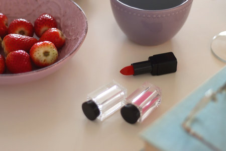 Plate of pastel macarons, cookies and chocolate, cup of tea of coffee, glass of bubble water, various berries, books and accessories on the table. Selective focus, pastel colors.の写真素材