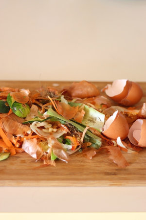 Chopping board with biowaste left from cooking. Selective focus.