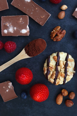 Macarons, chocolate, cookies, berries and various nuts on dark blue background. Top view.の写真素材