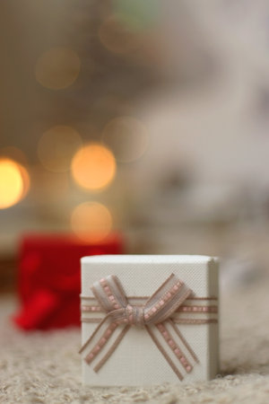 Various Christmas decorations, lit candles, cup of tea or coffee, cookies, books, presents and soft...