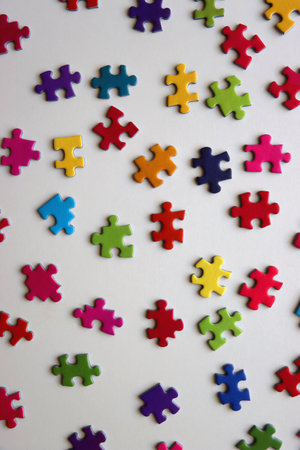 Colorful jigsaw puzzle pieces on white background. Flat lay.