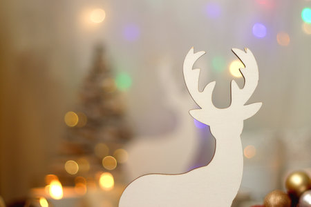 Various Christmas decorations, lit candles, cup of tea or coffee, cookies, books, presents and soft blanket on the table. Holiday hygge at home. Selective focus.の写真素材