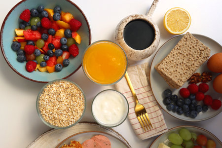Assortment of various breakfast foods and drinks on the white table. Flat lay.の写真素材