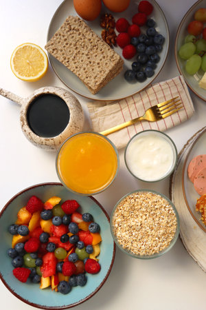 Assortment of various breakfast foods and drinks on the white table. Flat lay.の写真素材