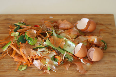 Chopping board with biowaste left from cooking. Selective focus.