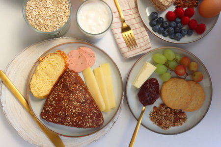 Assortment of various breakfast foods and drinks on the white table. Flat lay.の写真素材
