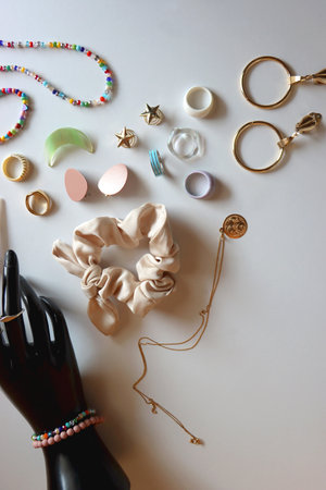 Hand figurine, sunglasses, gold jewelry, colorful bead jewelry, statement rings and various hair...