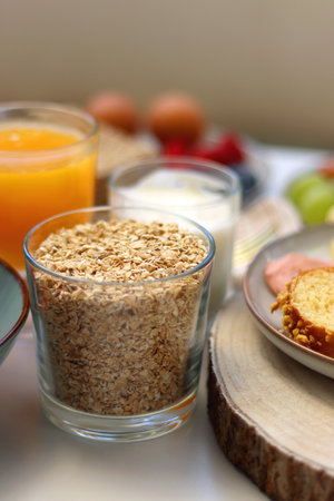 Assortment of various breakfast foods and drinks on the white table. Selective focus.
