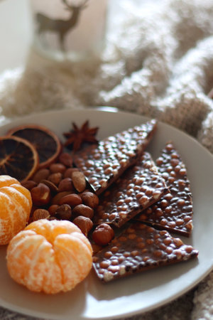 Books, e-reader, tea, orange juice, fruit, snacks, yarn, blanket and lit candles on the table. Autumn or winter hygge at home. Selective focus.の写真素材