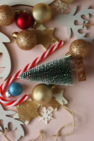 Various cute Christmas ornaments on pale pink background. Flat lay.の写真素材