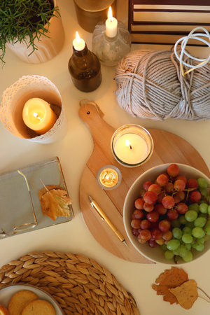 Pumpkins, various food and drinks, fall decorations, books and candles on the table. Fall hygge at home. Flat lay.の写真素材