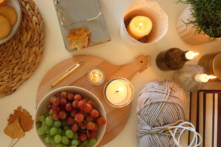 Various food and drinks, fall decorations, books and candles on the table. Fall hygge at home. Flat lay.の写真素材