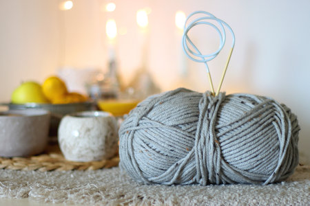 Books, e-reader, tea, orange juice, fruit, snacks, yarn, blanket and lit candles on the table....