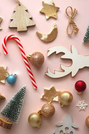 Various cute Christmas ornaments on pale pink background. Flat lay.の写真素材