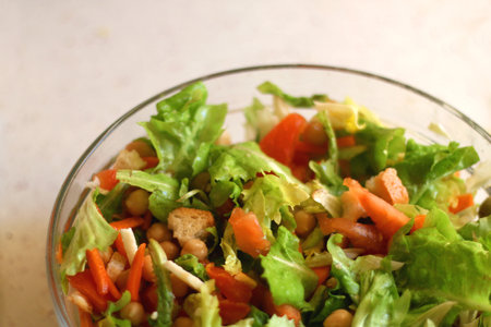 Bowl of lettuce, tomato, carrot, chickpea, cheese and toast salad. Selective focus.の写真素材