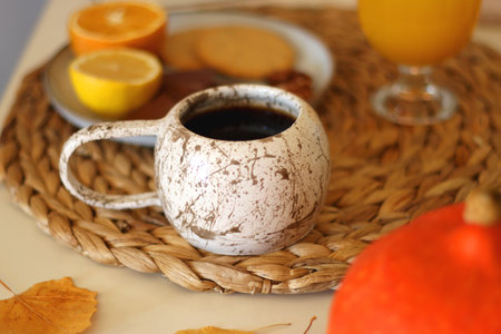 Pumpkins, various food and drinks, fall decorations, books and candles on the table. Fall hygge at home. Selective focus.の写真素材