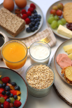 Assortment of various breakfast foods and drinks on the white table. Selective focus.の写真素材