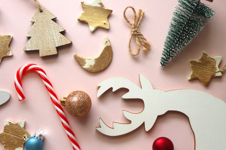 Various cute Christmas ornaments on pale pink background. Flat lay.の写真素材