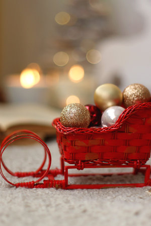 Various Christmas decorations, lit candles, cup of tea or coffee, cookies, books, presents and soft blanket on the table. Holiday hygge at home. Selective focus.の写真素材