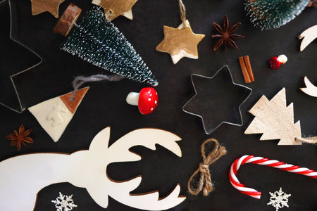 Various Christmas decorations in neutral colors on dark background. Top view.