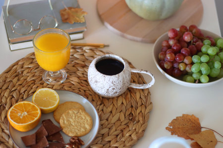 Pumpkins, various food and drinks, fall decorations, books and candles on the table. Fall hygge at home. Selective focus.の写真素材