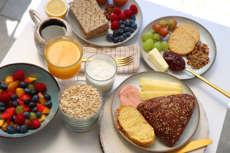 Assortment of various breakfast foods and drinks on the white table. Selective focus.の写真素材