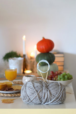 Pumpkins, various food and drinks, fall decorations, books and candles on the table. Fall hygge at home. Selective focus.の写真素材